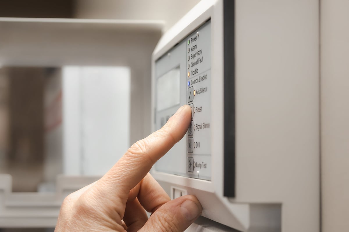 Técnico revisando panel de alarma contra incendio